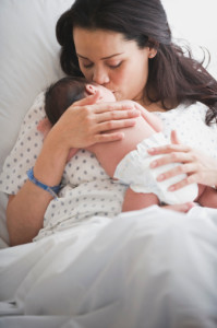 Mother in hospital bed holding newborn baby girl