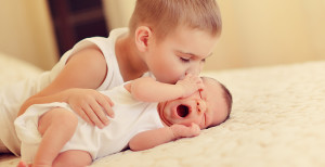 on the bed are two cute little brother the baby sleeps